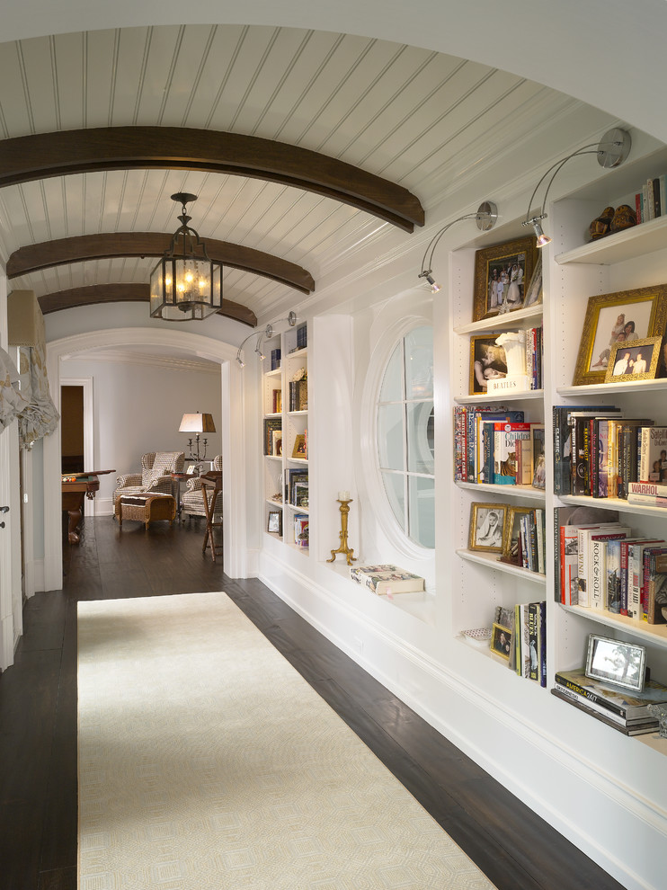 This is an example of a traditional hallway in Other with white walls and dark hardwood floors.