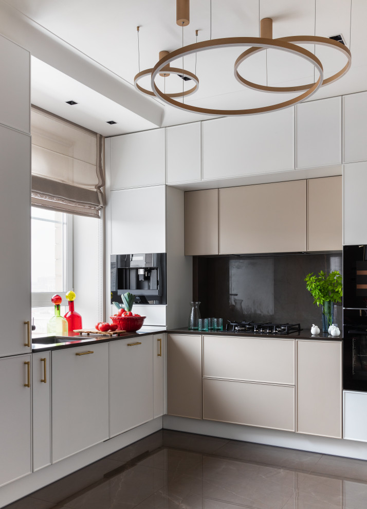 This is an example of a transitional l-shaped kitchen in Moscow with a single-bowl sink, white cabinets, black splashback, black appliances, no island, brown floor, black benchtop and window splashback.