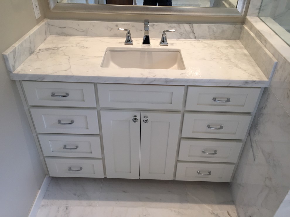 Example of a large minimalist master white tile and stone tile marble floor freestanding bathtub design in Dallas with an undermount sink, shaker cabinets, white cabinets, marble countertops, a one-piece toilet and white walls