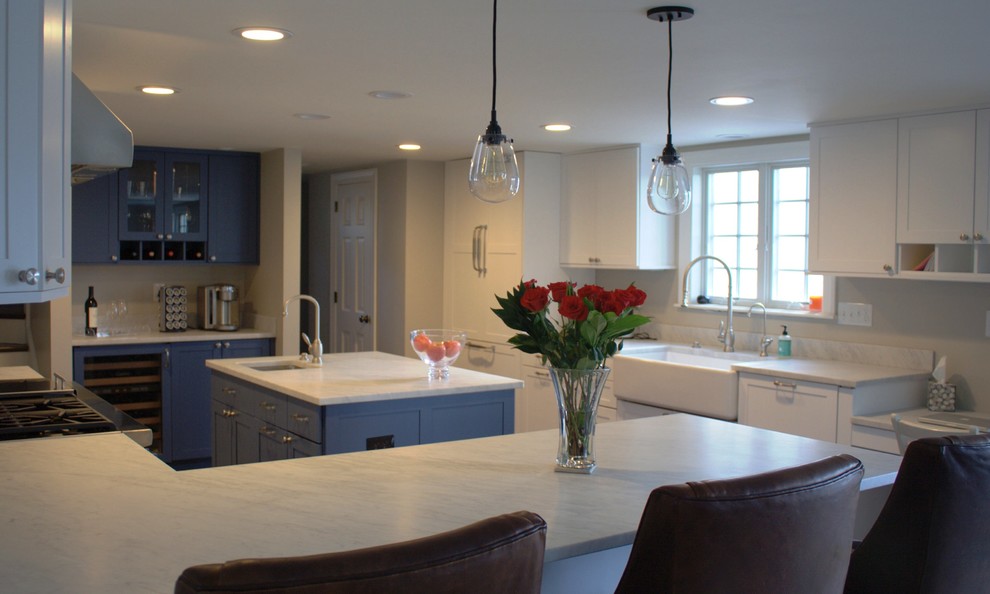 Photo of a mid-sized traditional l-shaped open plan kitchen in Boston with a farmhouse sink, recessed-panel cabinets, white cabinets, marble benchtops, panelled appliances, dark hardwood floors and with island.