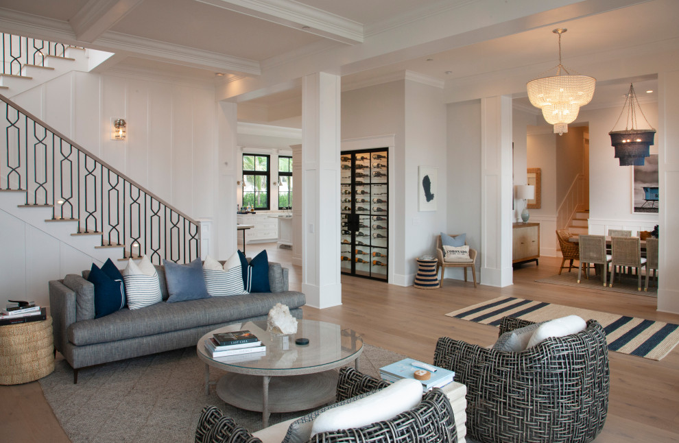Immagine di un grande soggiorno stile marino aperto con pareti bianche, parquet chiaro, pavimento beige, soffitto a cassettoni e pannellatura
