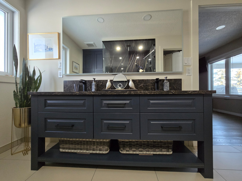 Walk-in shower - mid-sized transitional master black tile and porcelain tile porcelain tile, beige floor and double-sink walk-in shower idea in Edmonton with furniture-like cabinets, blue cabinets, beige walls, an undermount sink, quartz countertops, black countertops and a freestanding vanity