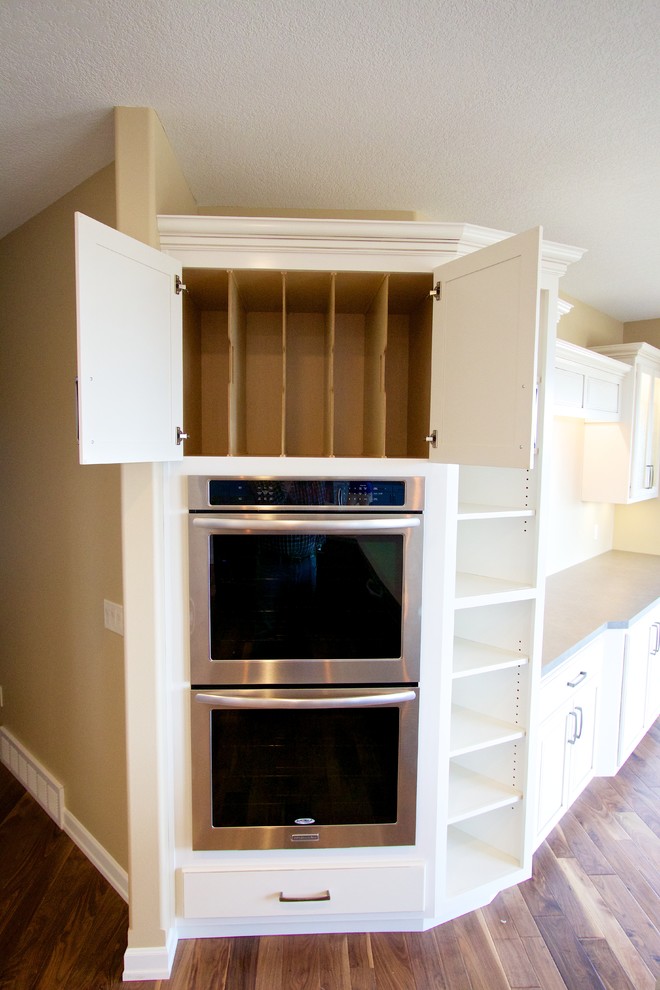 Open concept kitchen - huge open concept kitchen idea with a drop-in sink, raised-panel cabinets, white cabinets, multicolored backsplash, stone tile backsplash, stainless steel appliances and an island