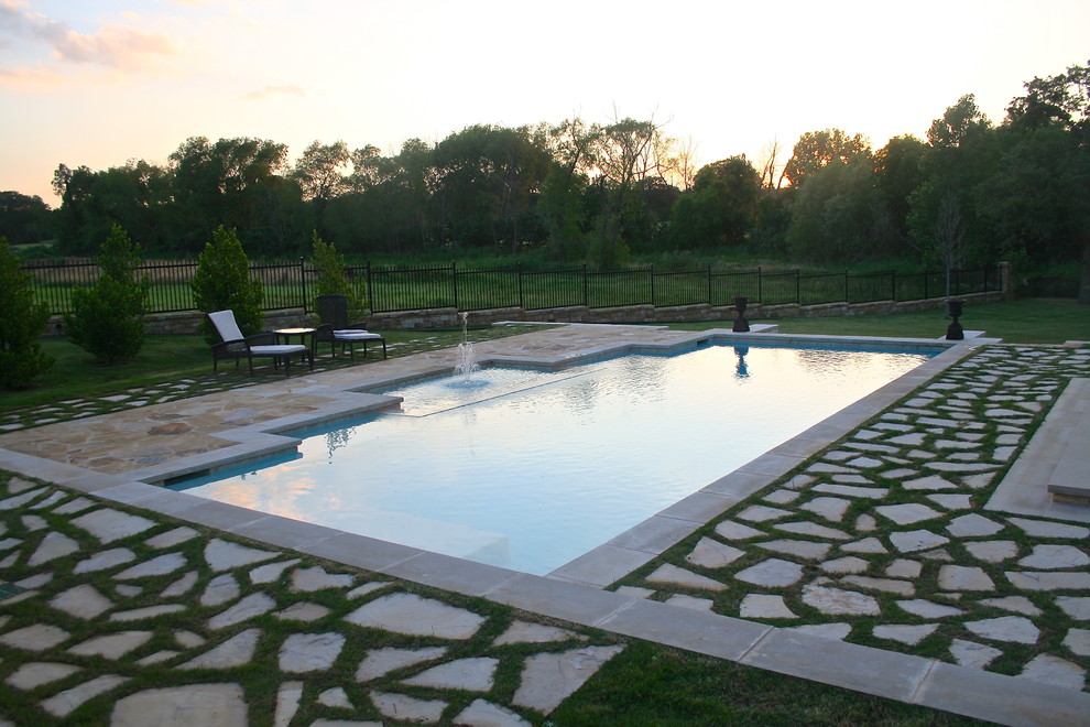 Photo of an expansive traditional backyard custom-shaped pool in Dallas with natural stone pavers.