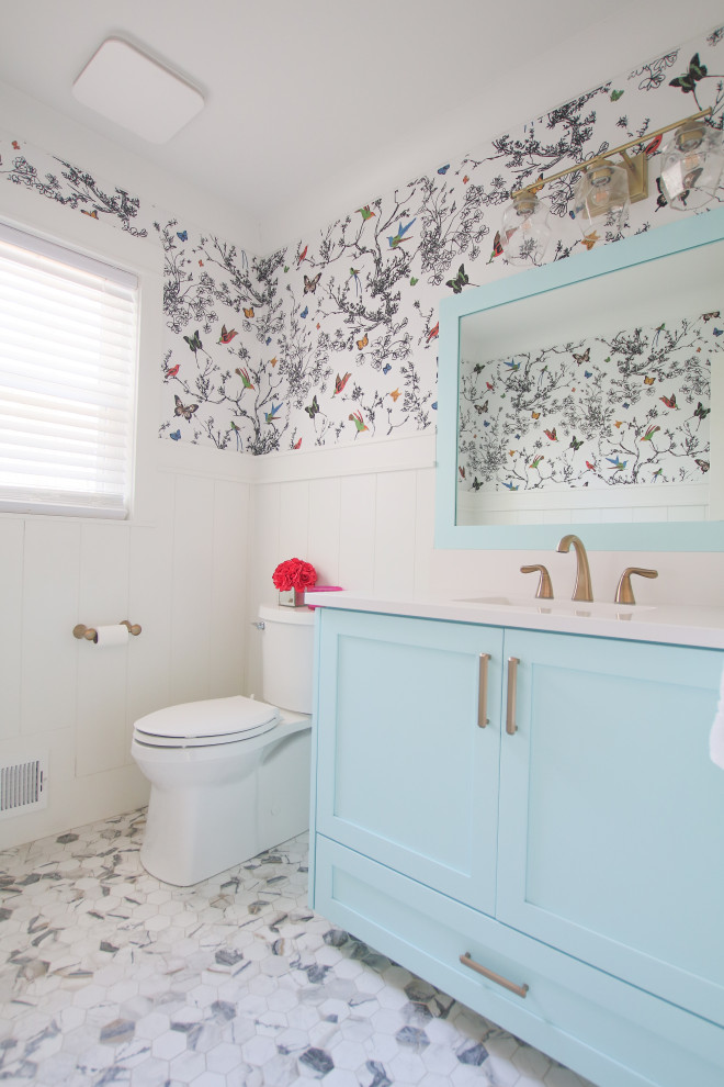 Ispirazione per un piccolo bagno di servizio chic con ante blu, lavabo sottopiano, top in quarzo composito, top bianco e carta da parati