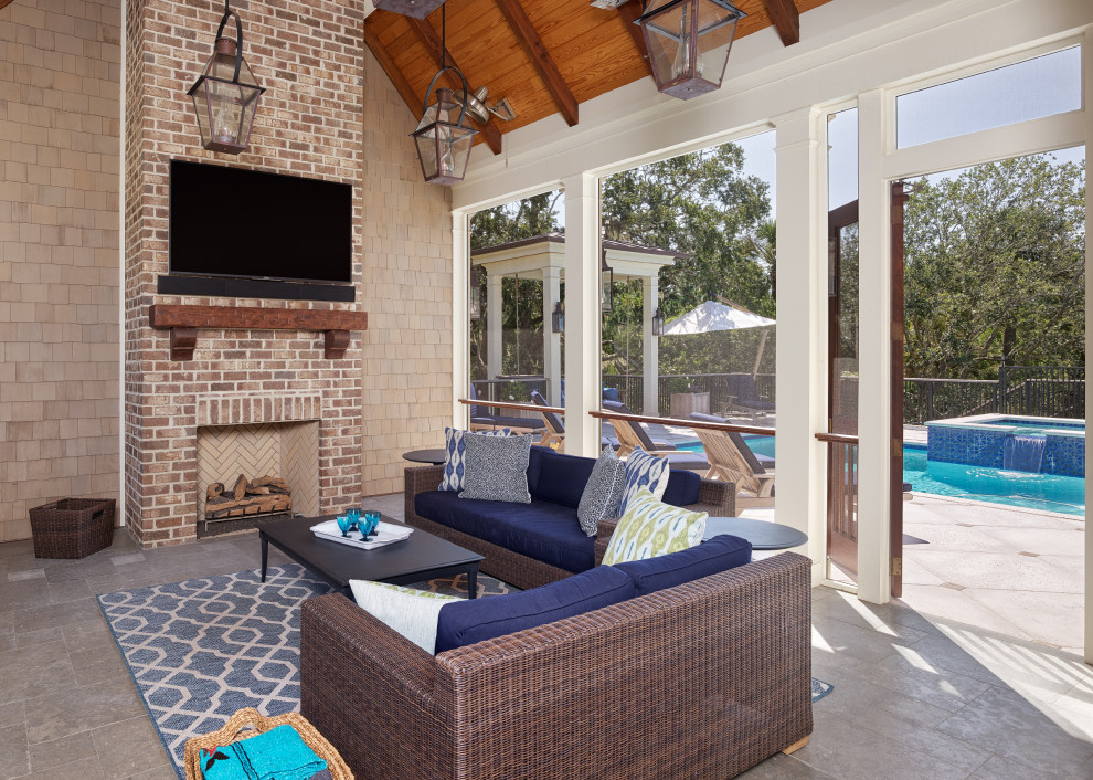 Large transitional backyard verandah in Charleston with with fireplace, a roof extension, tile and wood railing.