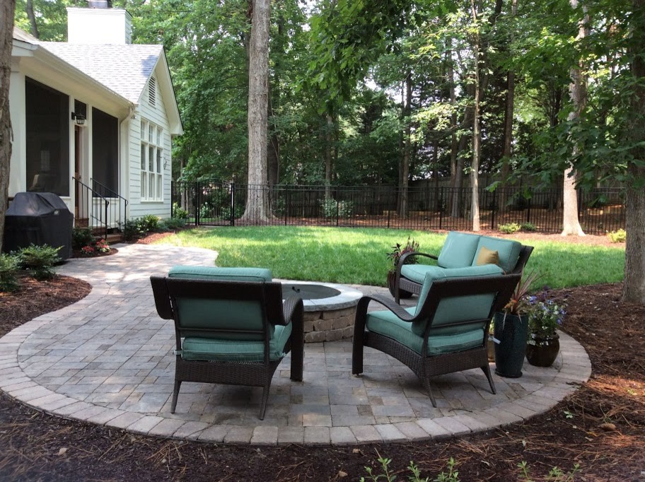 Inspiration for a mid-sized transitional backyard patio in Raleigh with tile, a roof extension and a water feature.
