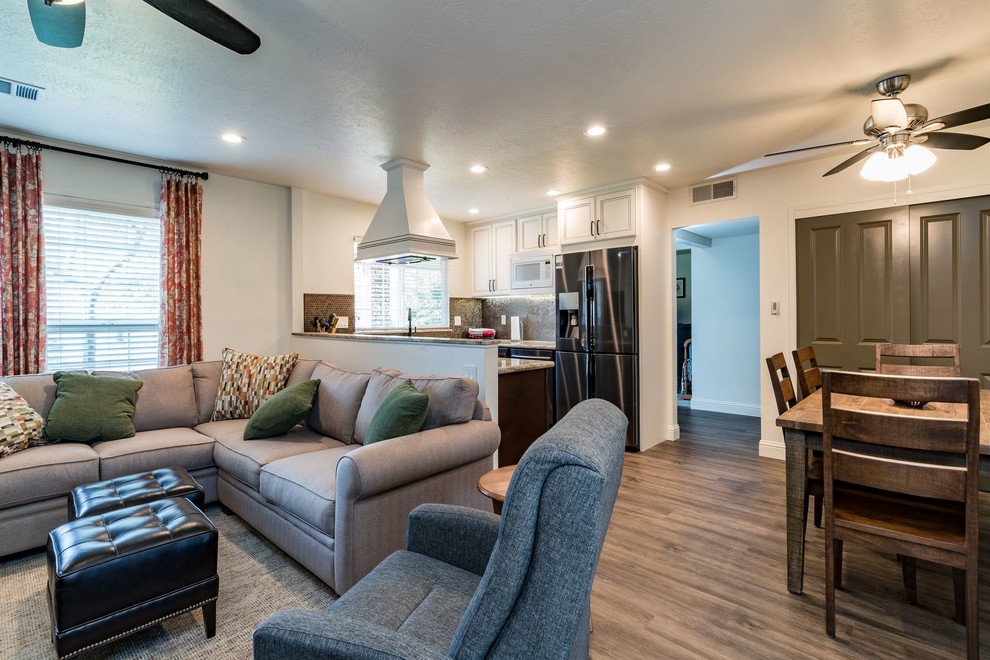 Inspiration for a mid-sized transitional u-shaped medium tone wood floor and brown floor eat-in kitchen remodel with an undermount sink, recessed-panel cabinets, white cabinets, granite countertops, brown backsplash, mosaic tile backsplash, stainless steel appliances and no island