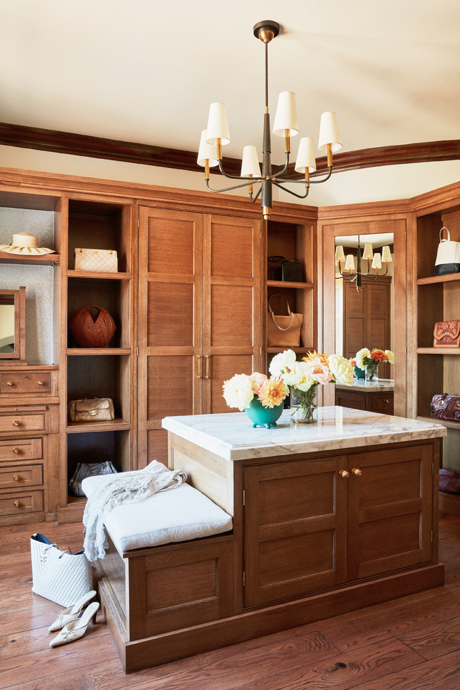 Inspiration for a large mediterranean women's dressing room in Los Angeles with recessed-panel cabinets, medium wood cabinets, medium hardwood floors and brown floor.