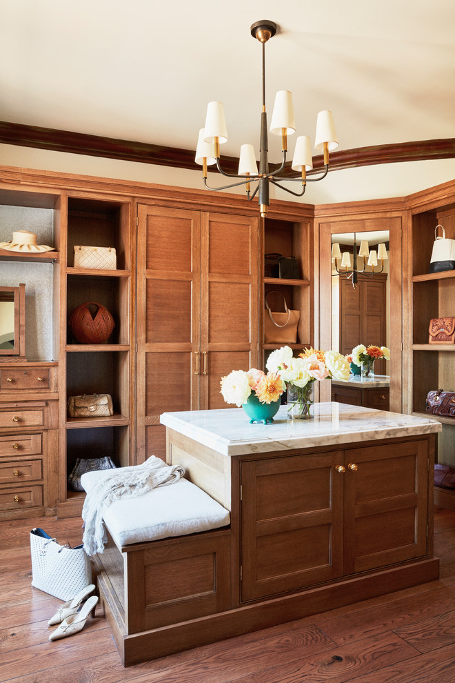 Inspiration for a large mediterranean women's medium tone wood floor and brown floor dressing room remodel in Los Angeles with recessed-panel cabinets and medium tone wood cabinets