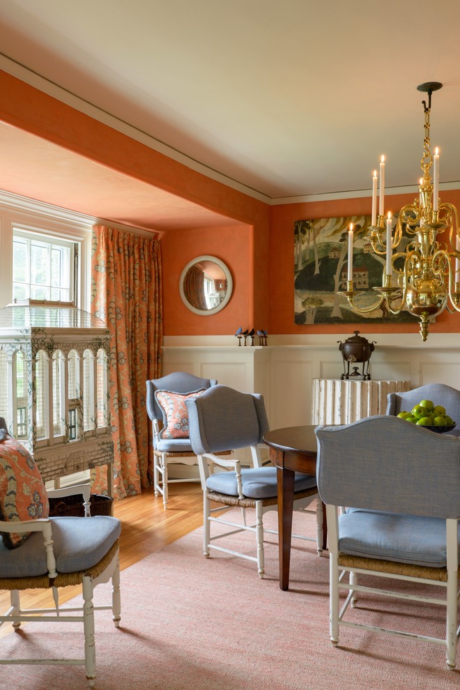 Photo of a mid-sized traditional kitchen/dining combo in Boston with orange walls and medium hardwood floors.