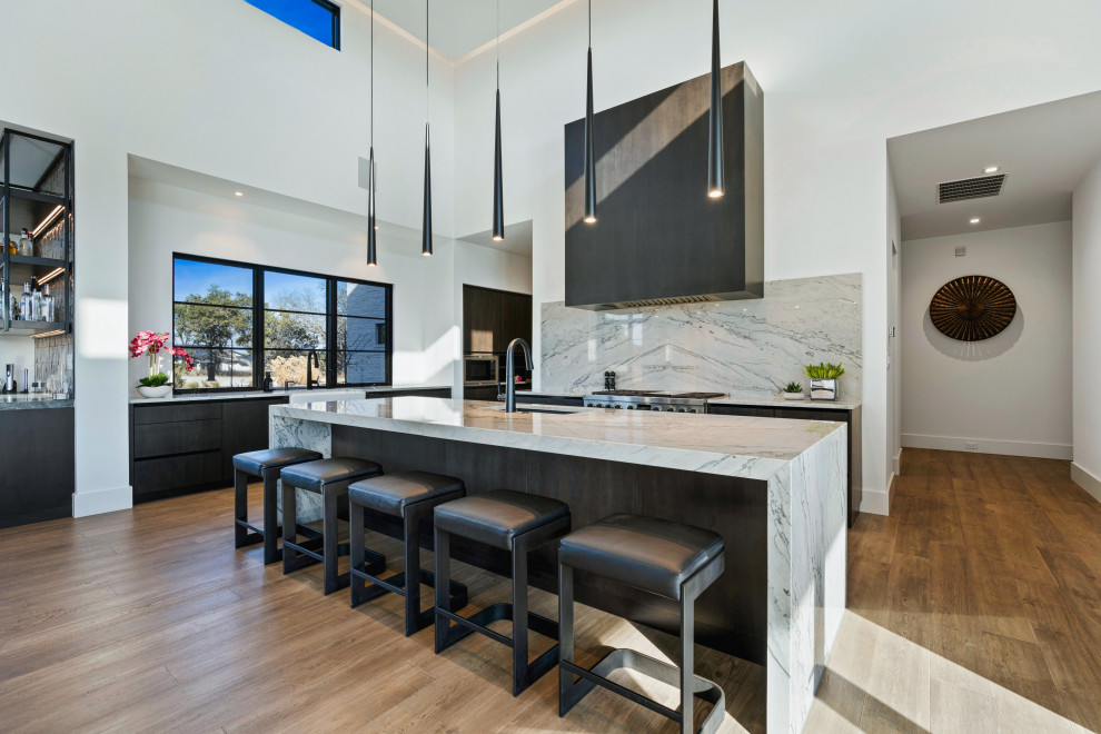 Eat-in kitchen - huge one-story multicolored, medium tone wood floor and brown floor eat-in kitchen idea with a farmhouse sink, flat-panel cabinets, dark wood cabinets, an island, white countertops and stainless steel appliances
