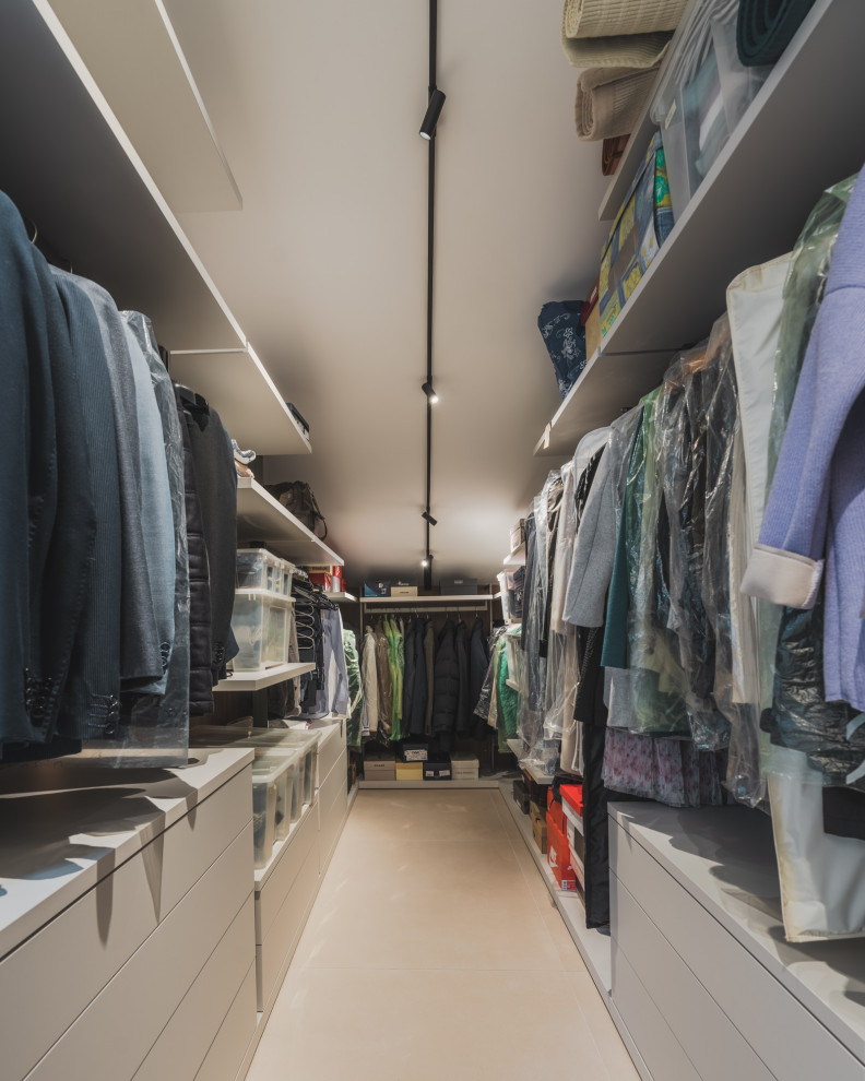 Photo of a large contemporary gender-neutral walk-in wardrobe in Milan with open cabinets, white cabinets, porcelain floors and beige floor.