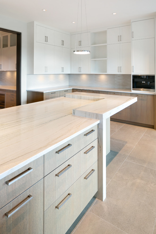 Inspiration for an expansive transitional u-shaped kitchen pantry in Vancouver with an undermount sink, flat-panel cabinets, light wood cabinets, quartzite benchtops, white splashback, ceramic splashback, stainless steel appliances, porcelain floors, with island and grey floor.
