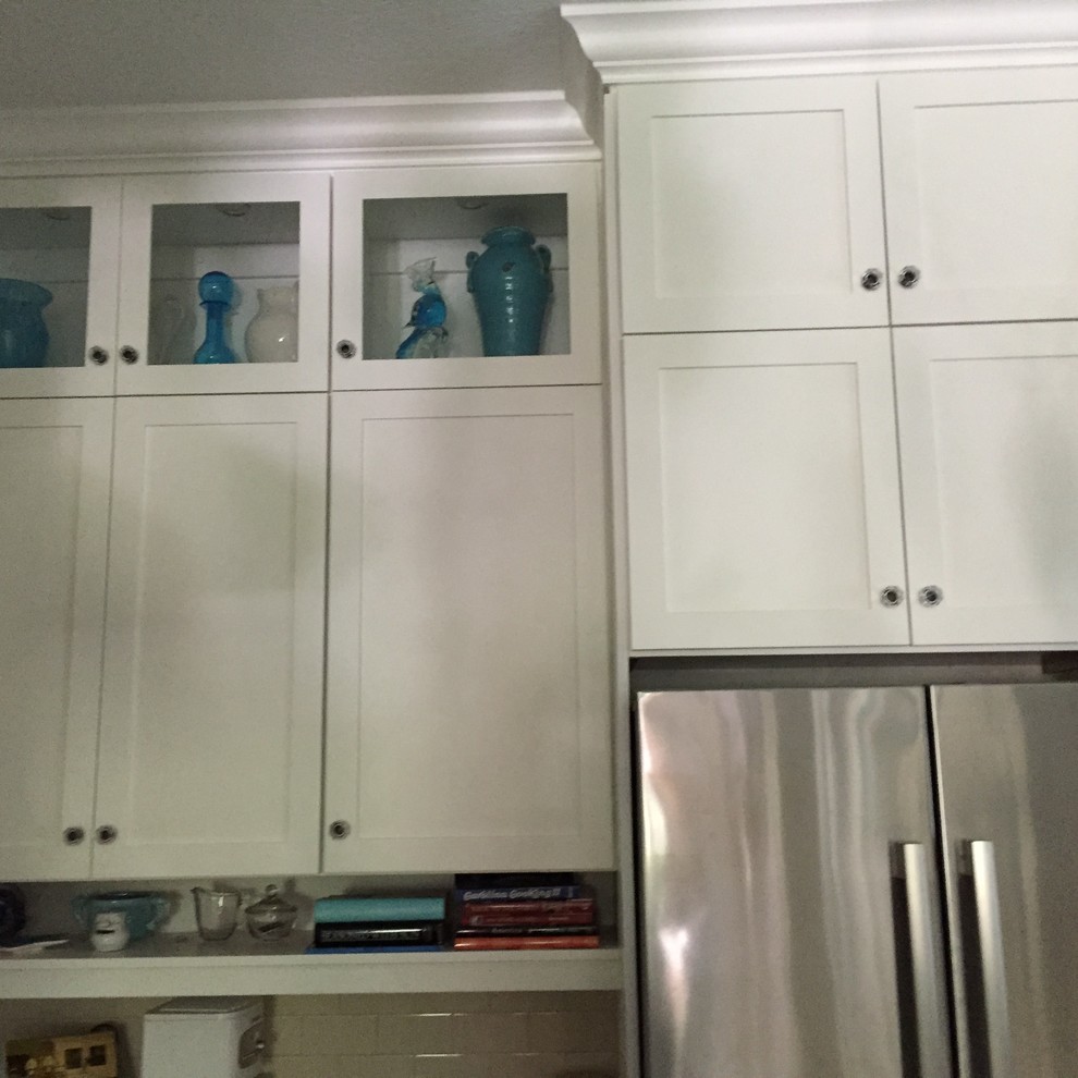 Mid-sized transitional l-shaped dark wood floor and brown floor eat-in kitchen photo in Miami with an undermount sink, shaker cabinets, white cabinets, white backsplash, subway tile backsplash, stainless steel appliances and an island