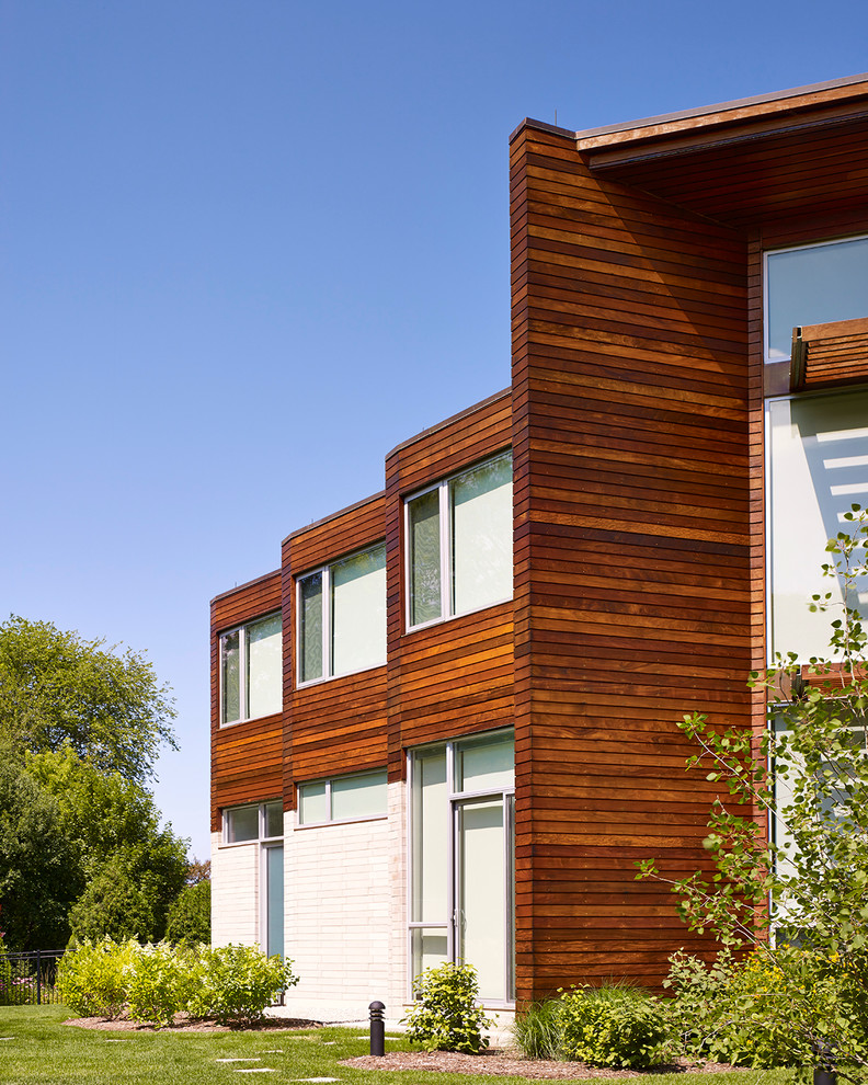 This is an example of an expansive contemporary two-storey multi-coloured house exterior in Chicago with wood siding and a flat roof.