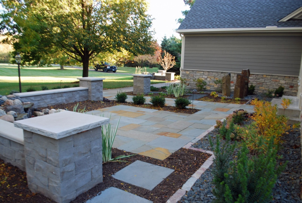 This is an example of a mid-sized traditional front yard partial sun garden for spring in Minneapolis with with path and natural stone pavers.