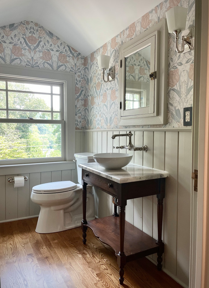 Design ideas for a small traditional powder room in Other with open cabinets, dark wood cabinets, a two-piece toilet, grey walls, a vessel sink, marble benchtops, brown floor, yellow benchtops, a freestanding vanity, vaulted and wallpaper.