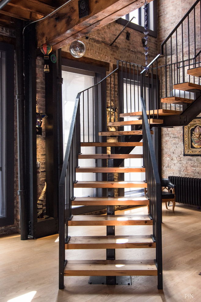 Eclectic wood floating staircase in Chicago with open risers and metal railing.