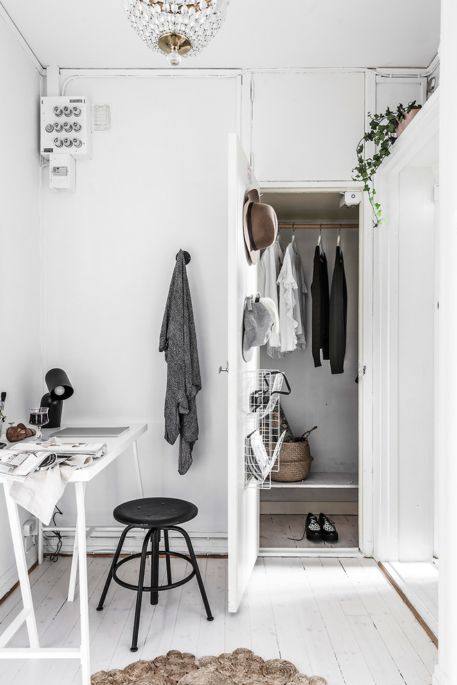Inspiration for a scandinavian storage and wardrobe in Gothenburg with flat-panel cabinets, white cabinets, painted wood floors and white floor.