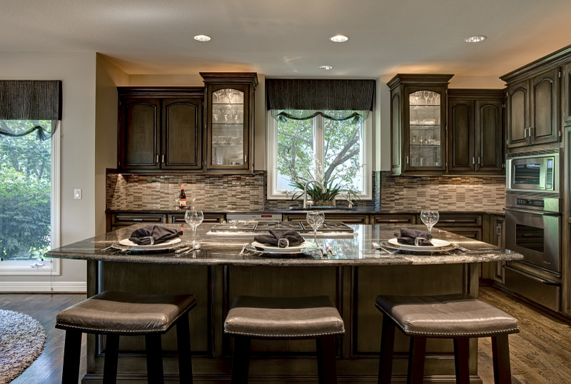 Example of a mid-sized transitional l-shaped dark wood floor eat-in kitchen design in Kansas City with dark wood cabinets, granite countertops, gray backsplash, mosaic tile backsplash, stainless steel appliances, an island, a double-bowl sink and beaded inset cabinets