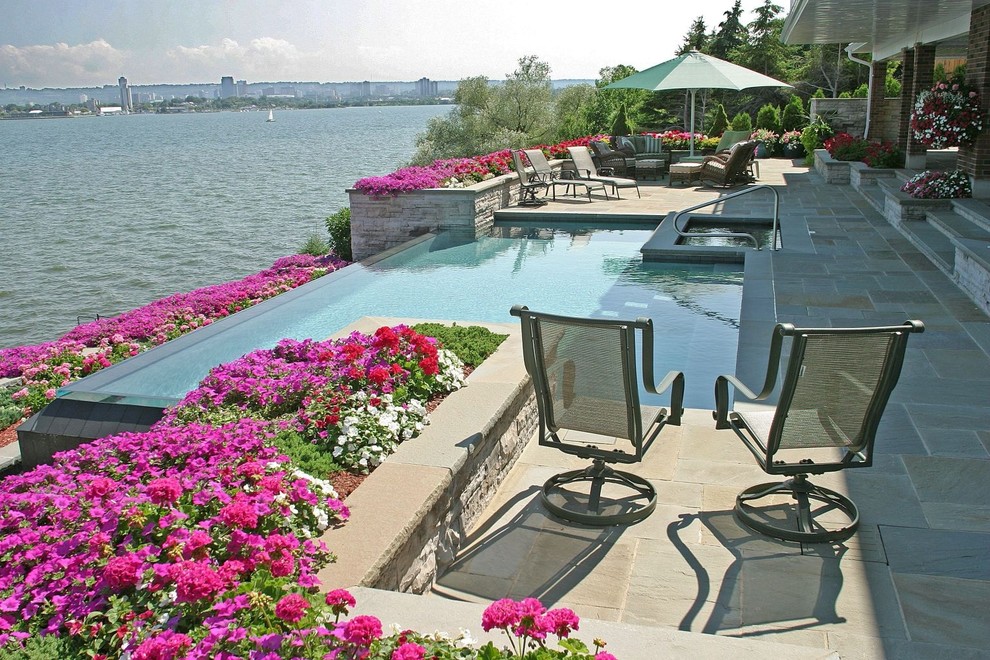 Mid-sized trendy backyard stone and rectangular infinity hot tub photo