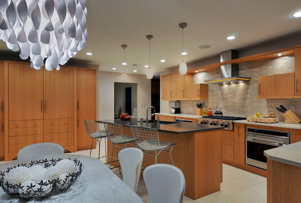 This is an example of a contemporary kitchen in New York with flat-panel cabinets, medium wood cabinets, beige splashback, stainless steel appliances and matchstick tile splashback.