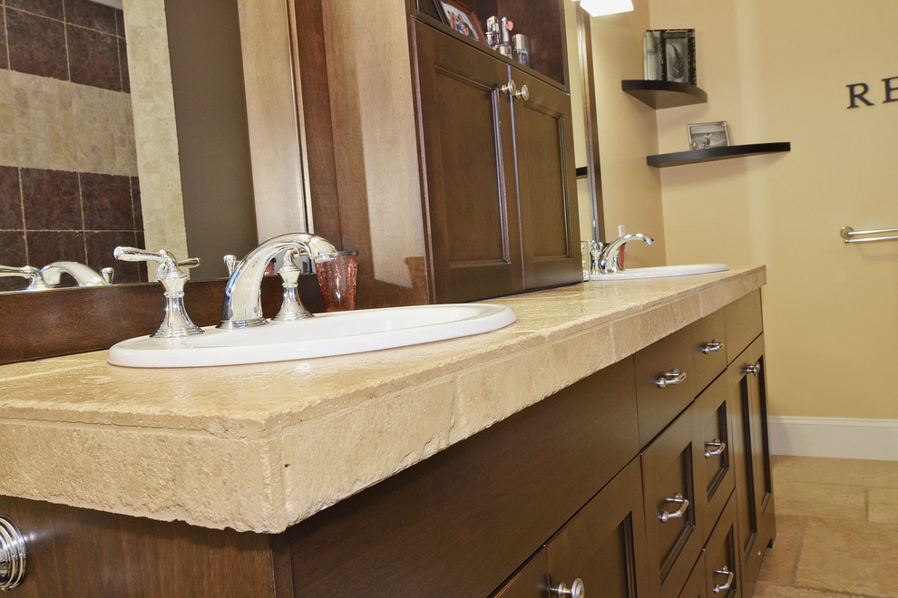 This is an example of a mid-sized arts and crafts master bathroom in Vancouver with dark wood cabinets, tile benchtops, beige tile, stone tile, yellow walls, travertine floors, recessed-panel cabinets, a two-piece toilet, a drop-in sink, a claw-foot tub and an open shower.