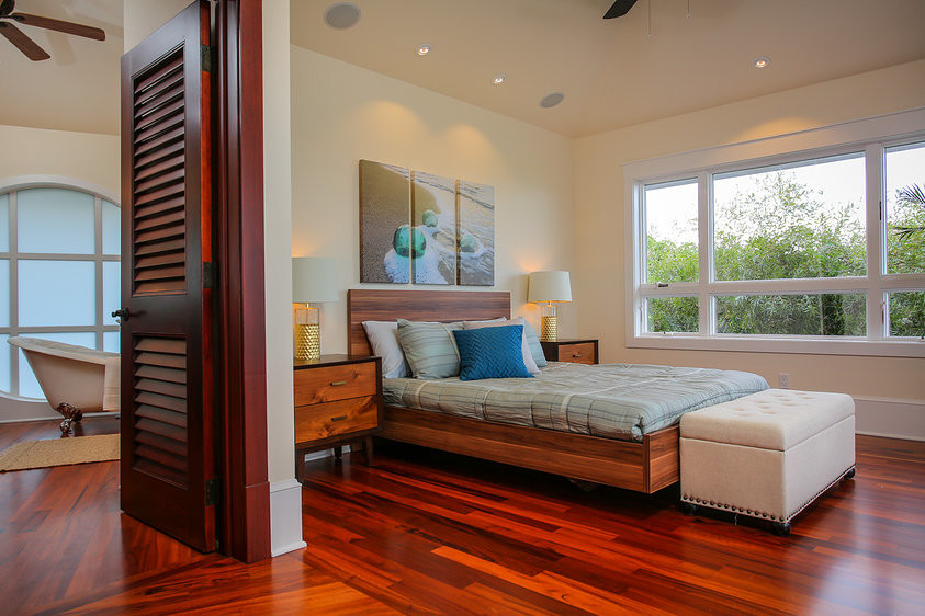 Inspiration for a large tropical guest bedroom in Hawaii with beige walls and dark hardwood floors.