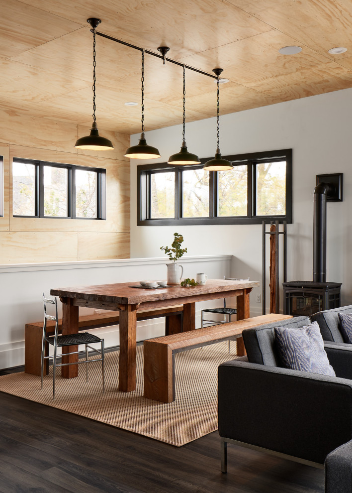 Cette image montre une salle à manger design en bois avec un mur blanc, parquet foncé, un sol marron et un plafond en bois.