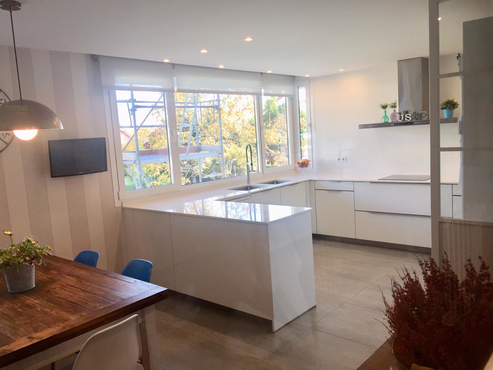 マドリードの中サイズのおしゃれなキッチン (グレーの床、白いキッチンカウンター) の写真