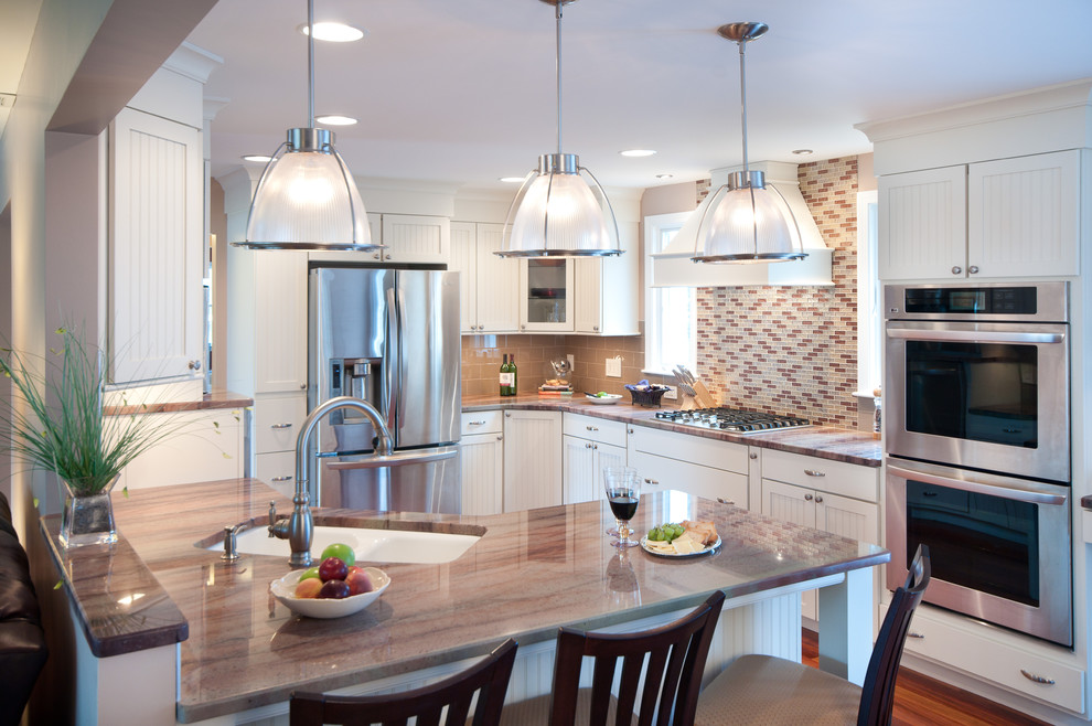 Inspiration for a large traditional u-shaped eat-in kitchen in Providence with subway tile splashback, granite benchtops, beige splashback, an undermount sink, shaker cabinets, white cabinets, stainless steel appliances, a peninsula and medium hardwood floors.