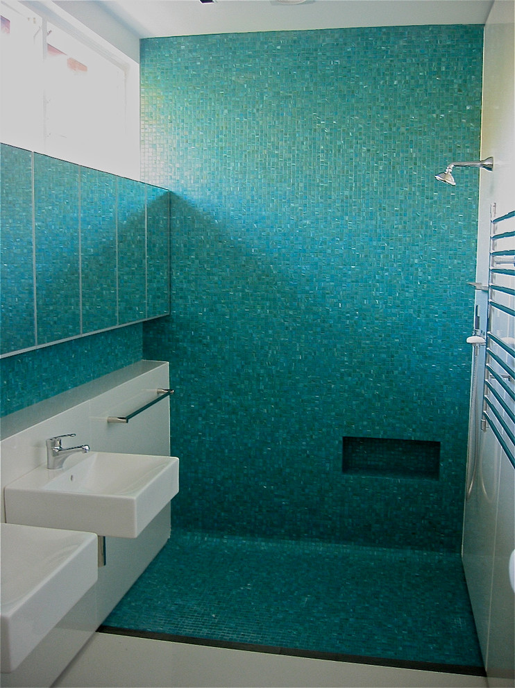 Photo of a mid-sized contemporary master bathroom in Sydney with a wall-mount sink, flat-panel cabinets, laminate benchtops, an open shower, a wall-mount toilet, green tile, mosaic tile, beige walls and porcelain floors.