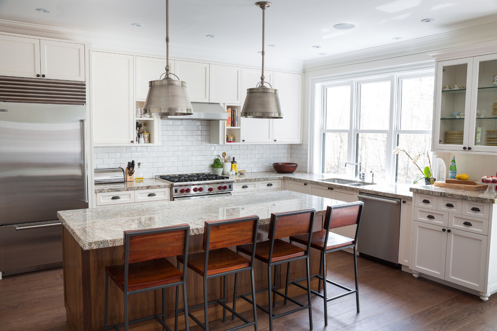 Large transitional u-shaped medium tone wood floor open concept kitchen photo in Toronto with a drop-in sink, shaker cabinets, white cabinets, marble countertops, white backsplash, subway tile backsplash, stainless steel appliances and an island