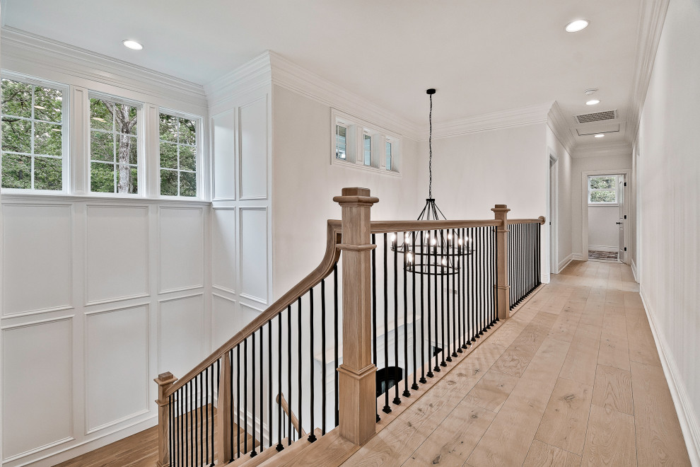 This is an example of a large arts and crafts wood u-shaped staircase in Other with wood risers, mixed railing and decorative wall panelling.