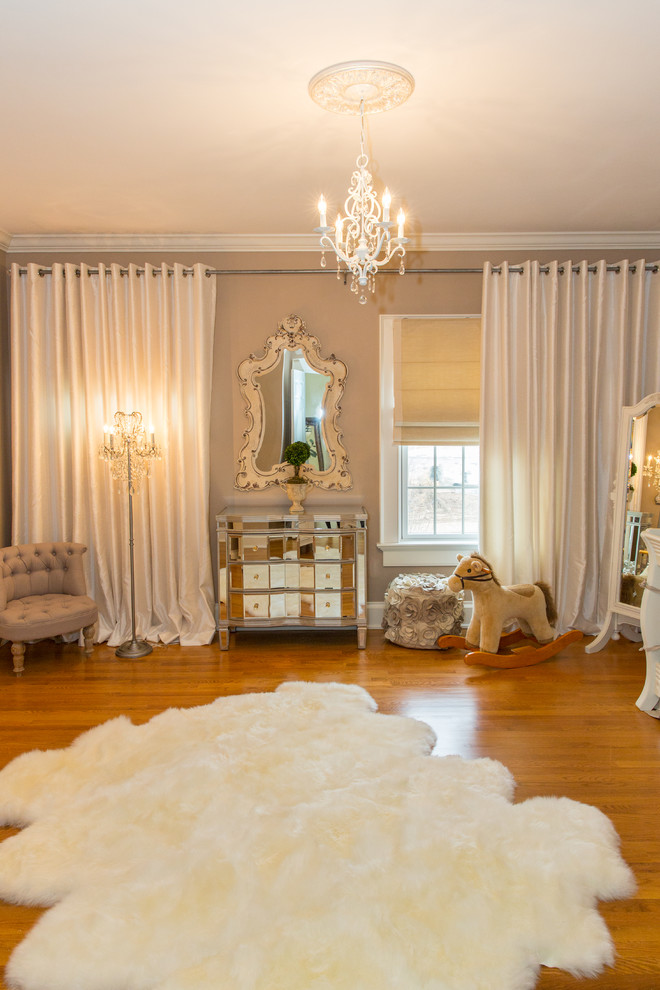 Photo of a large traditional gender-neutral nursery in New York with beige walls and medium hardwood floors.