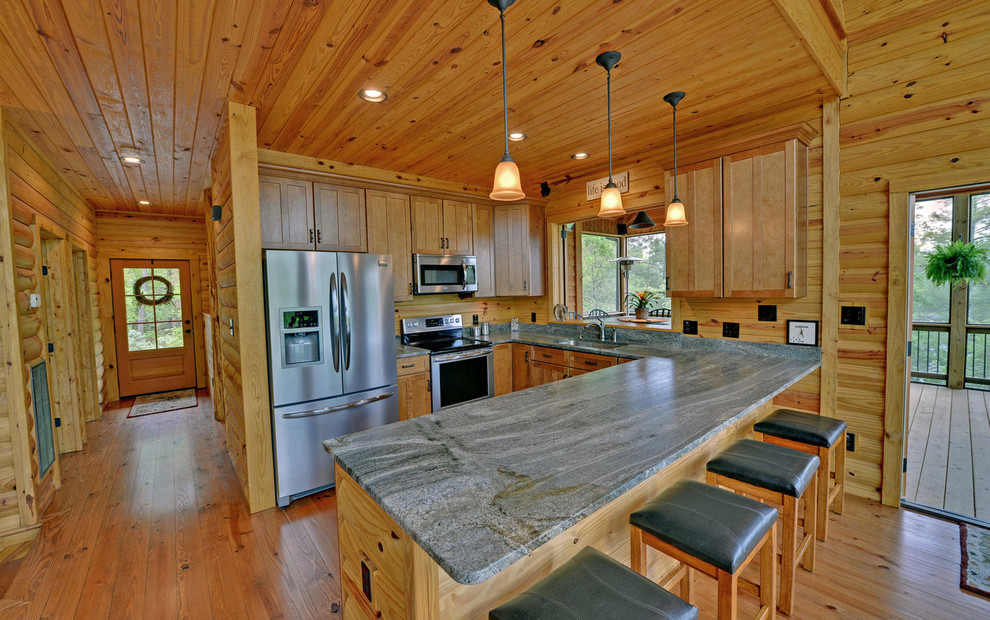 Example of a mid-sized mountain style u-shaped medium tone wood floor and brown floor eat-in kitchen design with an undermount sink, shaker cabinets, medium tone wood cabinets, granite countertops, gray backsplash, stone slab backsplash, stainless steel appliances and a peninsula