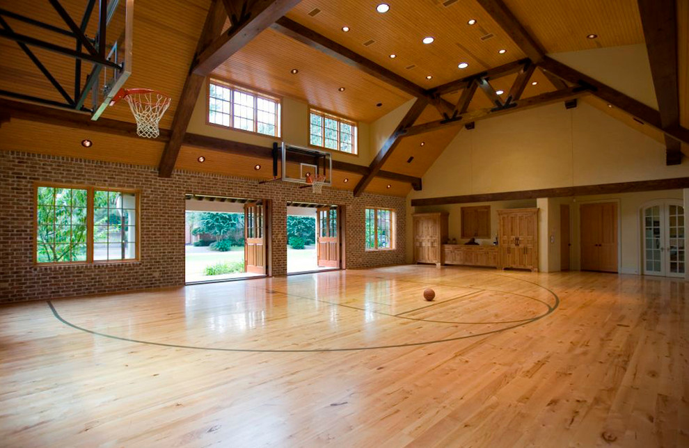 This is an example of an expansive traditional indoor sport court in Houston with yellow walls and light hardwood floors.