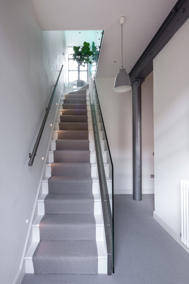 Photo of an industrial painted wood straight staircase in London with painted wood risers.