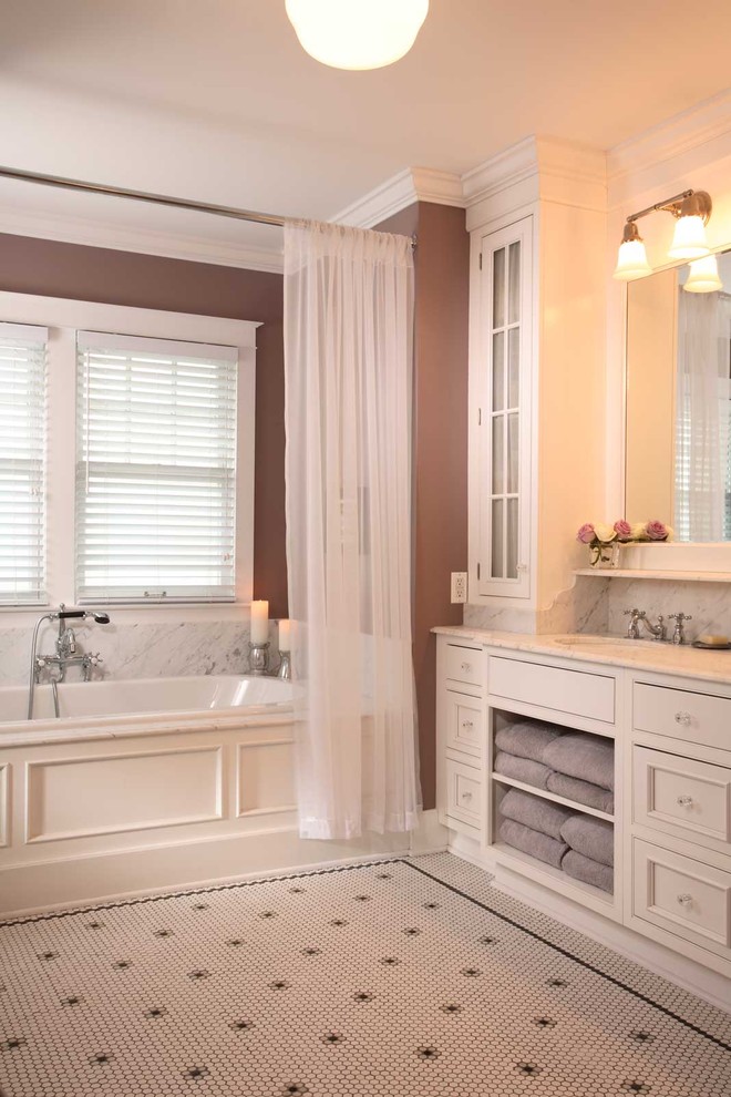 Design ideas for a mid-sized traditional master bathroom in Chicago with an undermount sink, white cabinets, marble benchtops, a drop-in tub, white tile, brown walls, ceramic floors, recessed-panel cabinets and a shower curtain.