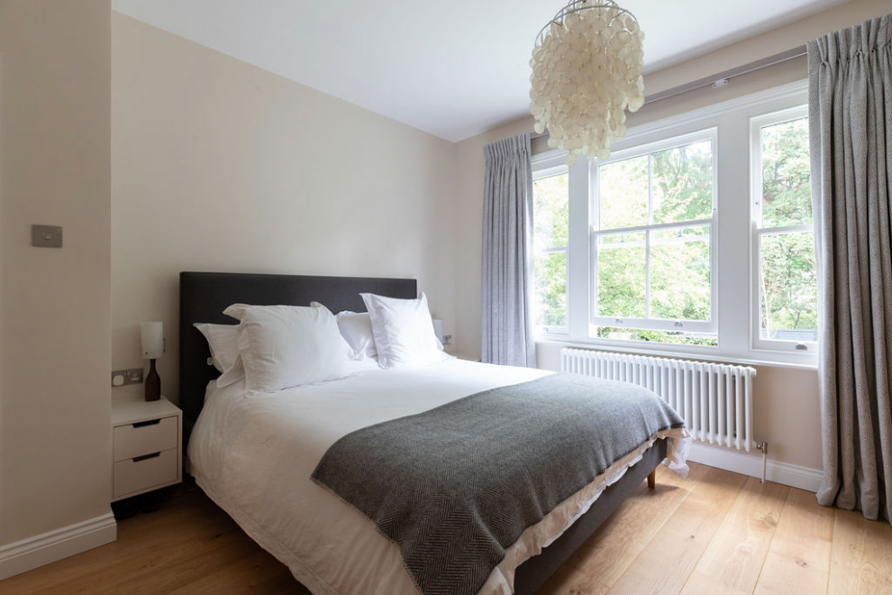 Mittelgroßes Modernes Hauptschlafzimmer mit weißer Wandfarbe, hellem Holzboden und weißem Boden in London