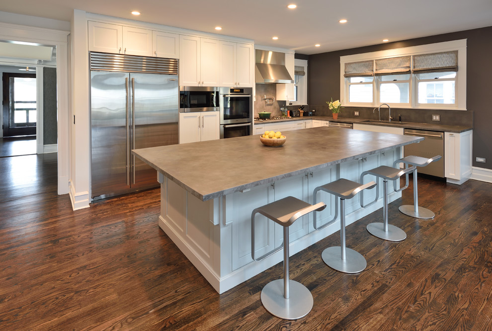 Inspiration for a contemporary l-shaped open plan kitchen in Chicago with an integrated sink, beaded inset cabinets, white cabinets, concrete benchtops, grey splashback, cement tile splashback, stainless steel appliances, medium hardwood floors and with island.