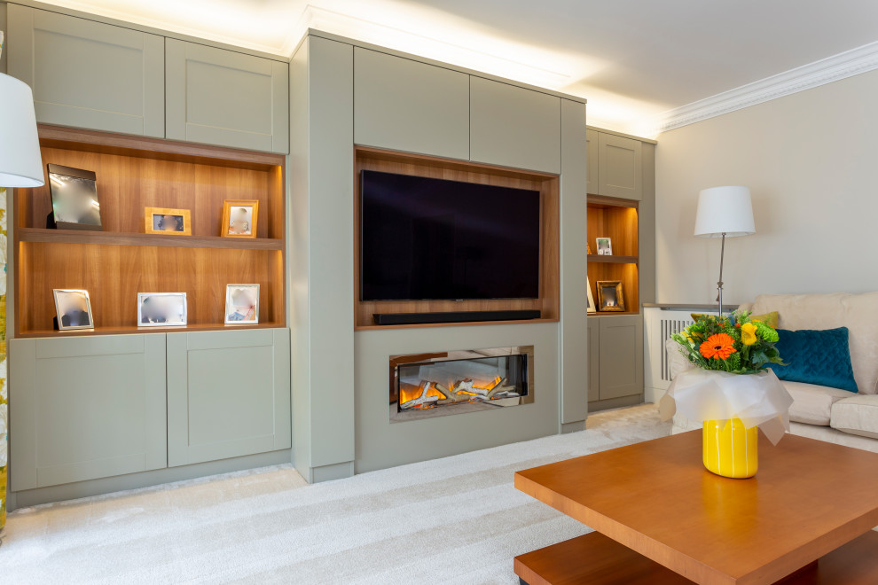 This is an example of a large modern enclosed living room in Hertfordshire with a music area, grey walls, carpet, a hanging fireplace, a wood fireplace surround, a built-in media wall and beige floor.