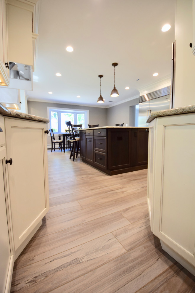 Inspiration for a huge transitional vinyl floor and brown floor eat-in kitchen remodel with a farmhouse sink, recessed-panel cabinets, white cabinets, quartz countertops, multicolored backsplash, ceramic backsplash, stainless steel appliances, an island and multicolored countertops