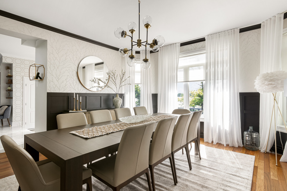 This is an example of a large classic open plan dining room in Montreal with white walls, a tiled fireplace surround, pink floors and wainscoting.