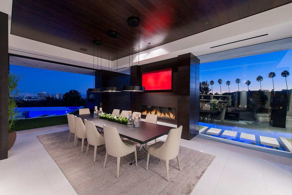 This is an example of an expansive contemporary open plan dining in Los Angeles with white walls, white floor, porcelain floors, a standard fireplace and recessed.