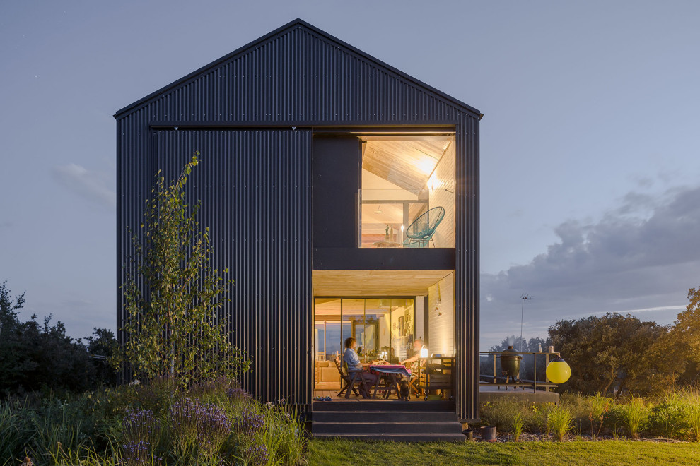 Foto de fachada de casa negra de estilo de casa de campo de tamaño medio de dos plantas con revestimiento de metal, tejado a dos aguas y tejado de metal