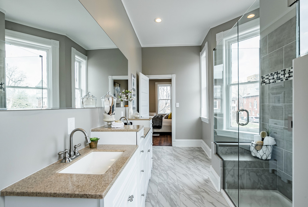 Inspiration for a mid-sized arts and crafts master bathroom in St Louis with furniture-like cabinets, white cabinets, a curbless shower, a one-piece toilet, grey walls, ceramic floors, a drop-in sink, granite benchtops, grey floor, a hinged shower door and beige benchtops.