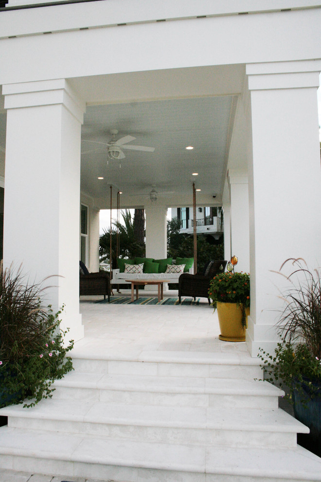 Design ideas for a large beach style two-storey stucco white exterior with a gable roof.