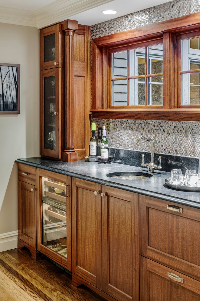 Inspiration for a mid-sized transitional single-wall wet bar in Boston with an undermount sink, flat-panel cabinets, dark wood cabinets, granite benchtops, green splashback, glass sheet splashback, medium hardwood floors, brown floor and green benchtop.